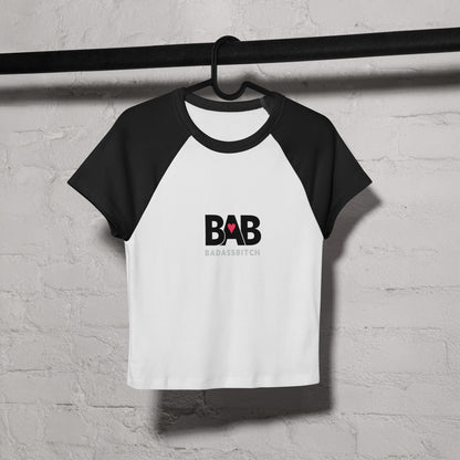 BAB Badass raglan baby tee in black and white with red heart graphic – on coat hanger view
