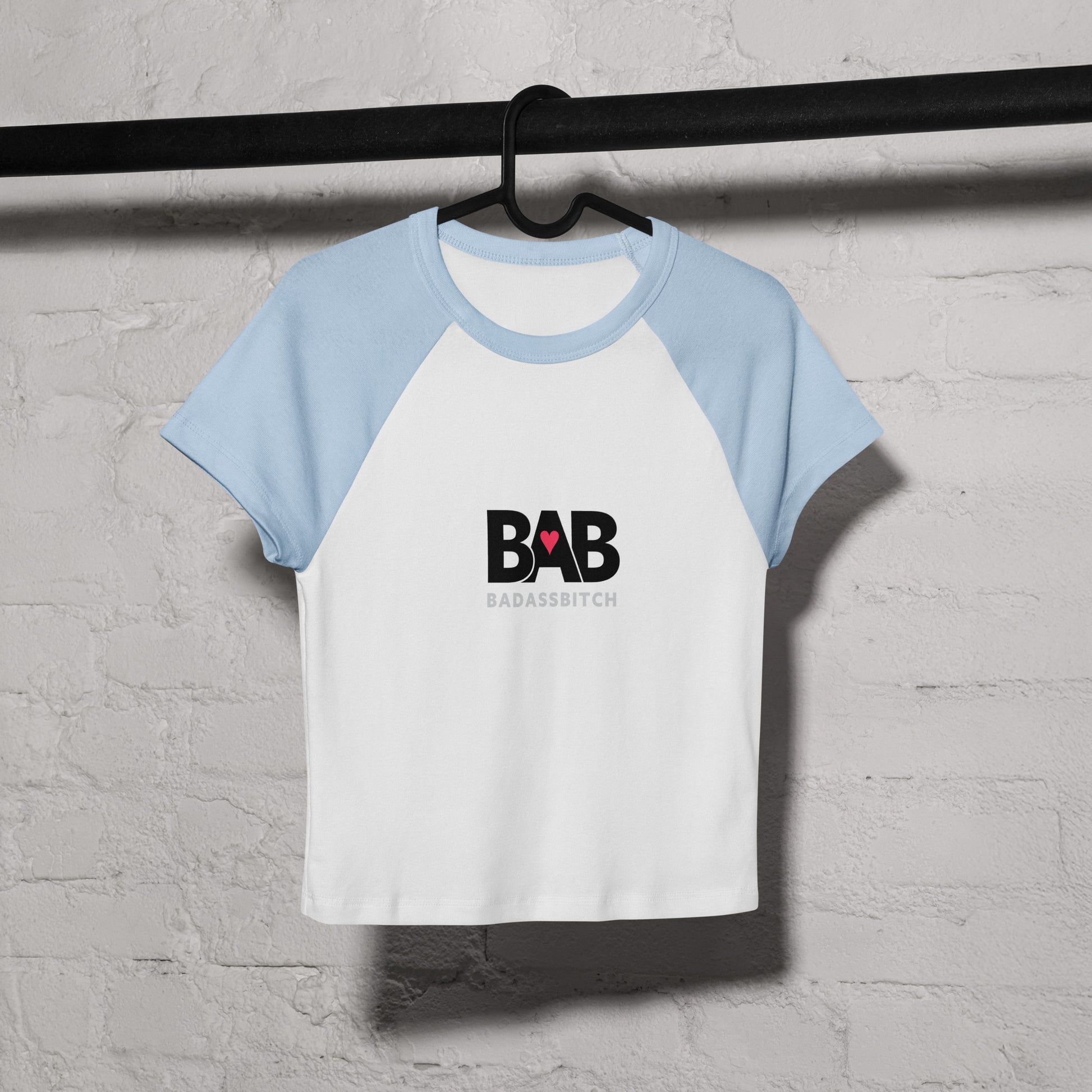 BAB Badass raglan baby tee in light blue and white with red heart graphic – on coat hanger view